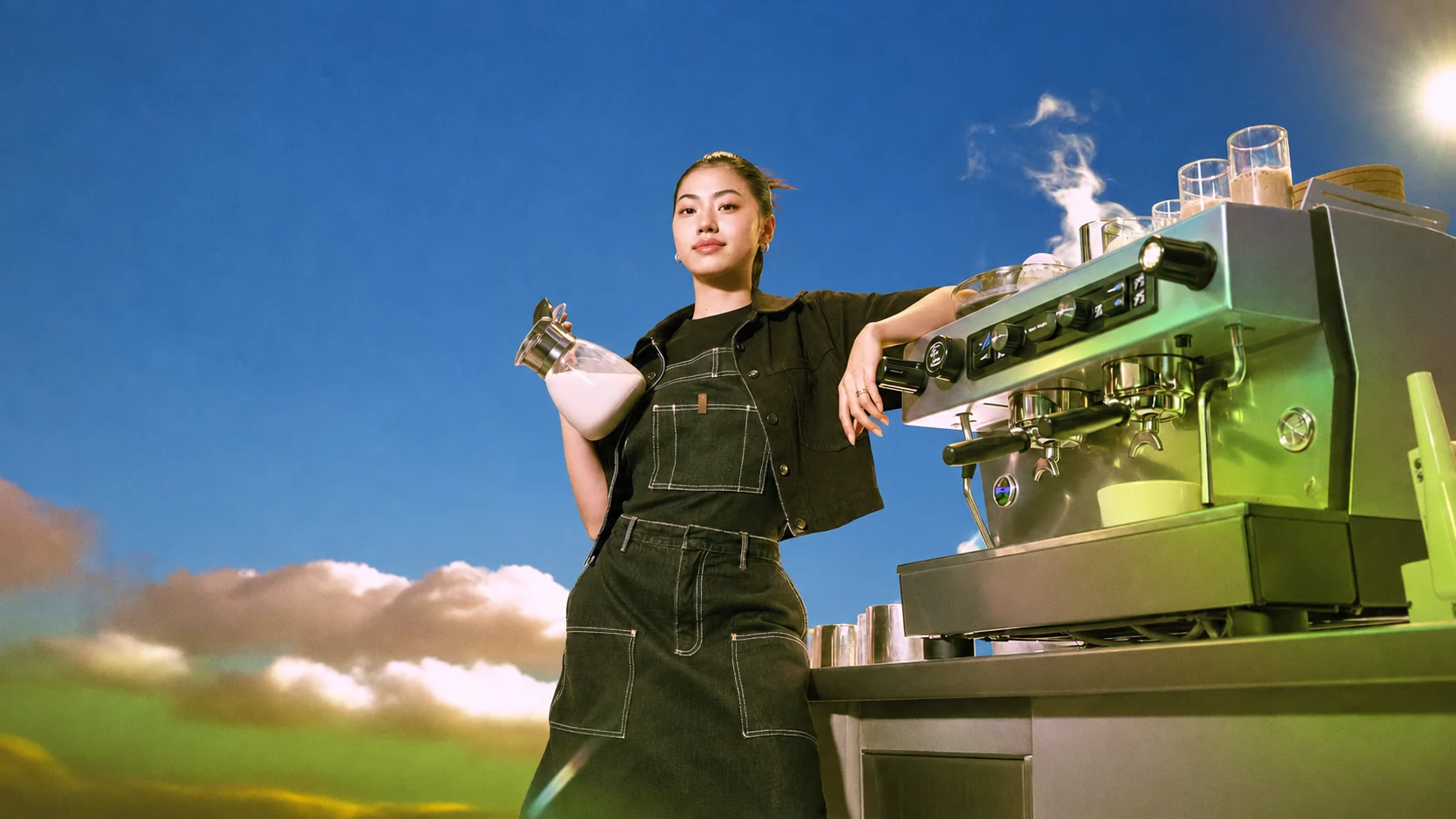 A barista preparing a rice drink beside an espresso machine under a bright blue sky