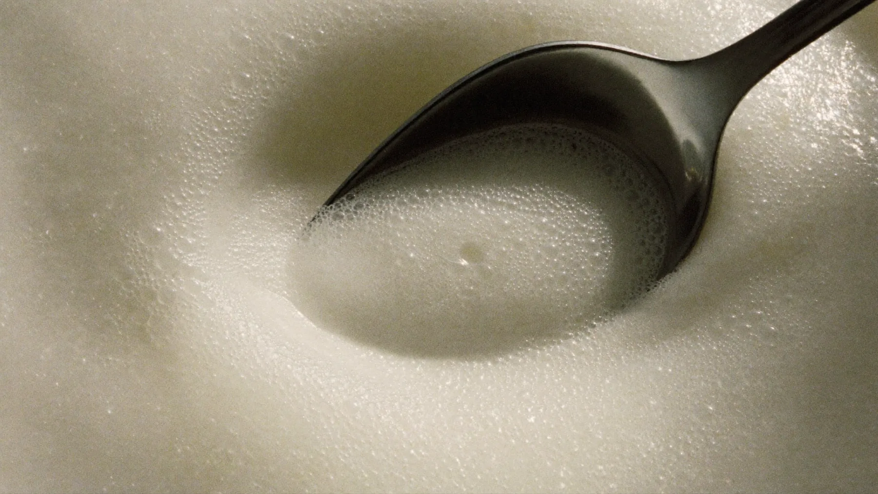 A spoon resting in delicate creamy foam